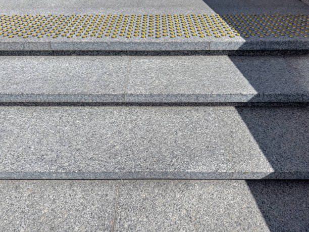 istock outdoors granite staircase with yellow nonskid bumpy markings on steps. 1611116654