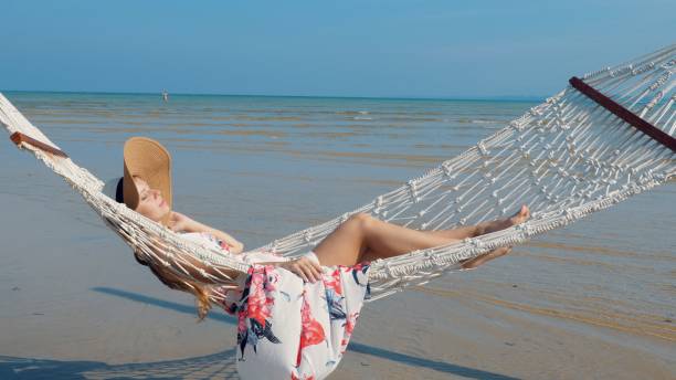 istock Beach girl enjoying hammock swing at sunny seaside 1611285730