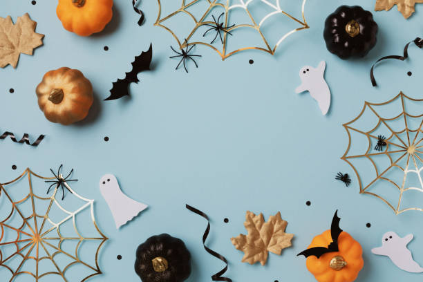 istock Halloween holiday frame with party decorations from pumpkins, bats, spider web and ghosts top view. Happy halloween greeting card on blue background flat lay. 1611294975