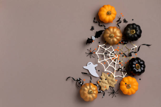 istock Halloween party decorations from pumpkins, bats, spider web and ghosts top view. Happy halloween holiday greeting card flat lay. 1611296551
