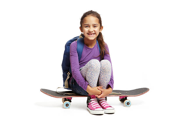 istock Young school girl sitting on a skateboard 161131773