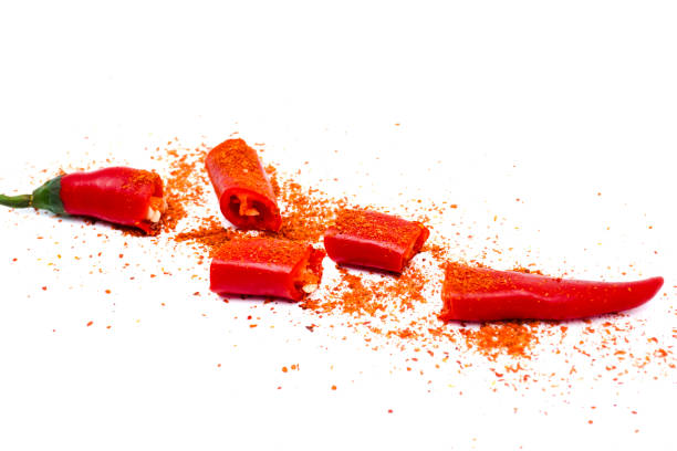 Sliced red chilli or chilli cayenne pepper decorated with chilli powder isolated on white background. Cut red hot chili pepper with copy space.