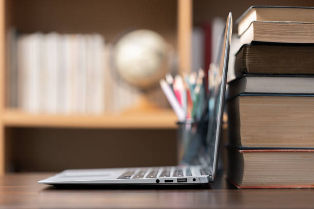 istock Education learning concept. Book in library with old open textbook, stack piles of literature text archive on reading desk, aisle of bookshelves in school study class room background for academic 1611330716