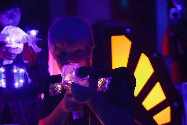A boy playing laser tag.  Photographed at a high ISO under blacklight to capture true look and feel of the game.