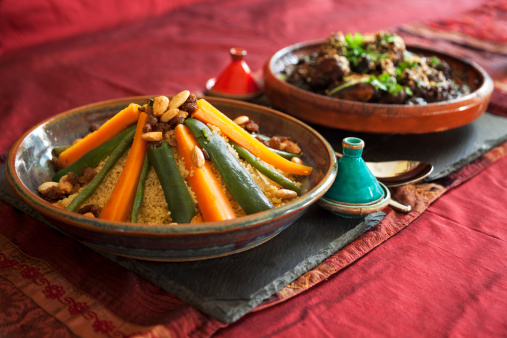 Vegetable couscous and Meat and prune tagine garnished with fresh coriander and sesame seeds.  Authentic pepper and salt pots and table linen.