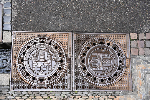 Prague, Czech Republic - July 10, 2020: Prague manhole cover of sewage well, cast iron sewer cover.