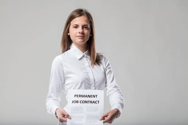 istock Woman in white, shows contract, stresses stability 1611433517