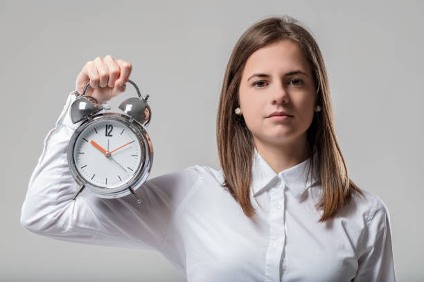istock ady with clock encourages respecting deadlines 1611435162