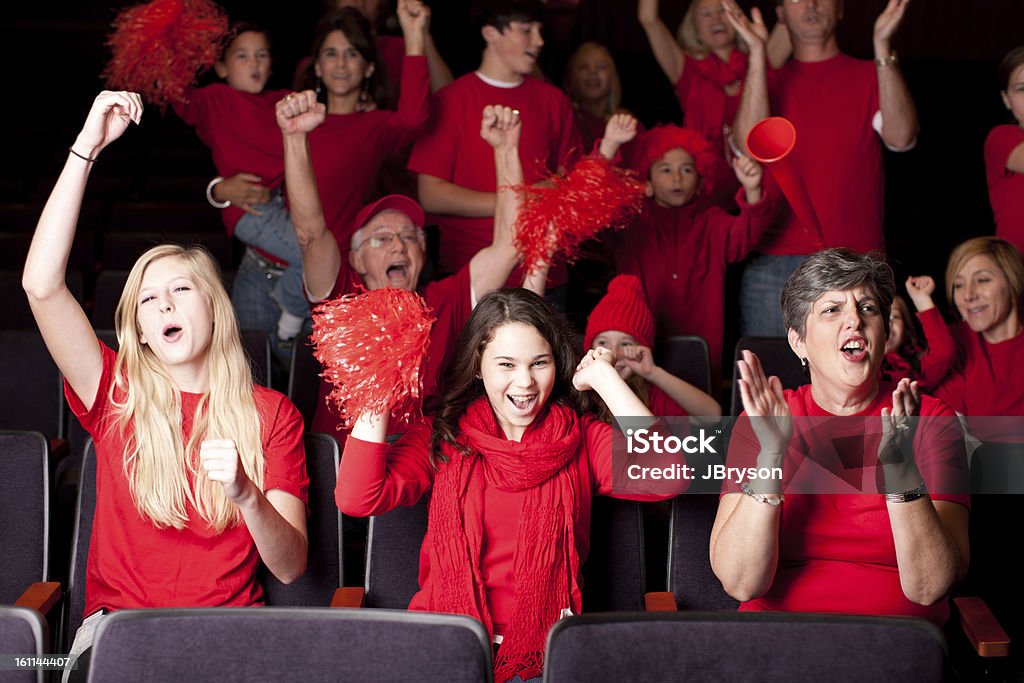 Sports Fans: Adults Children Excited Spectators Team Color Red A group of sports fans - real adults and children are excited spectators as the cheer on their team at a sports event.  Team Color Red. Shallow DOF.  Sport Stock Photo