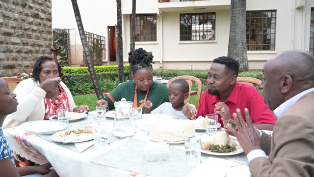 Three generations enjoying outdoor midday meal in Nairobi
