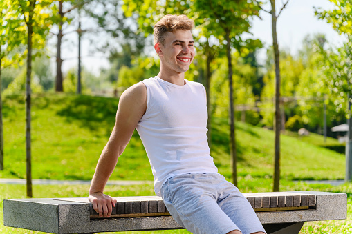 Athlete man doing push-ups on bench in park. Training triceps workout concept fitness, sport.