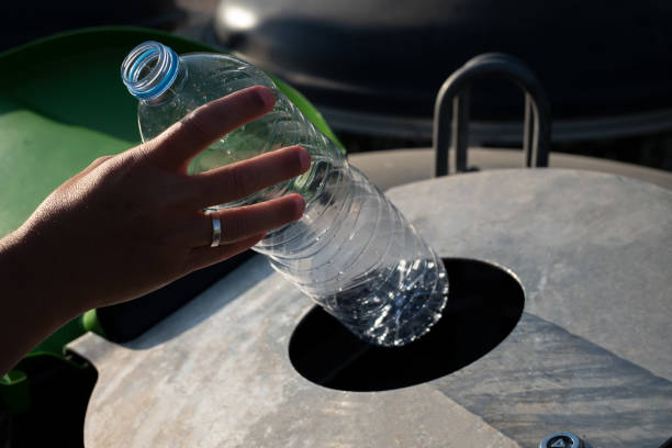 istock A woman inserts plastic bottles into the recycling container 1611501069