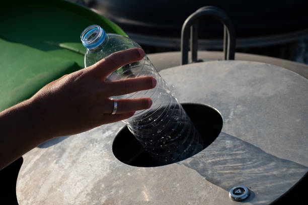istock A woman inserts plastic bottles into the recycling container 1611501078