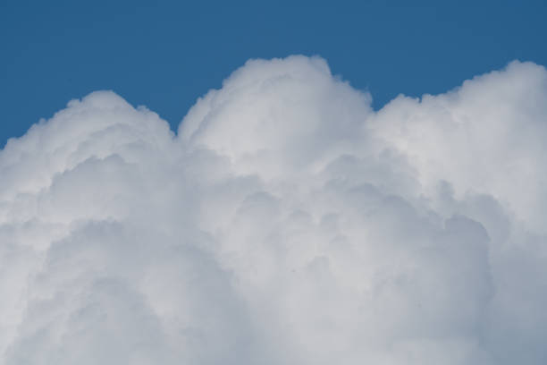 istock white fluffy clouds standing out against  a blue sky 1611503716