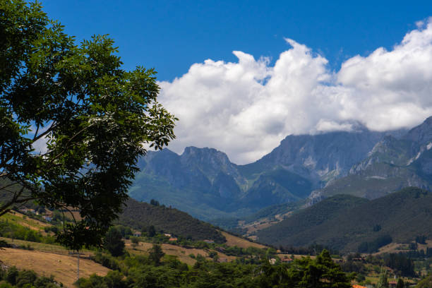 istock Tall Mountains, White Clouds, and Green Meadow: Beautiful Scenic View 1611527850