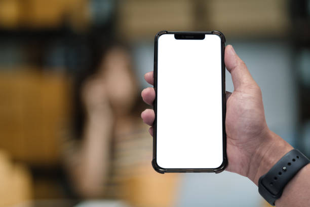 Man holding smartphone with blank screen, close-up of hands. Space for text.
