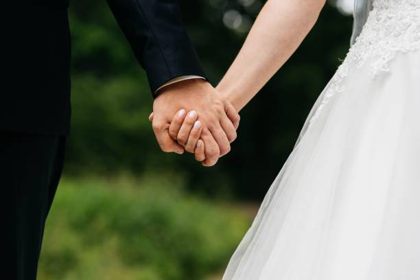 istock two people are holding hands and they're looking at each other 1611542672