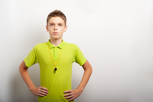a teenage boy with a whistle looks like a sports coach or referee