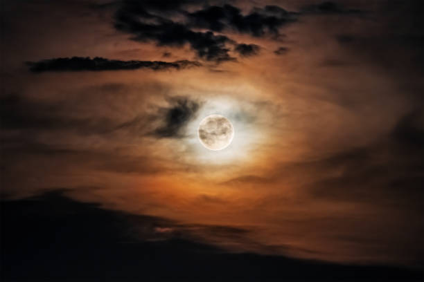 istock Full moon in multicolored transparent clouds in the night sky 1611560885