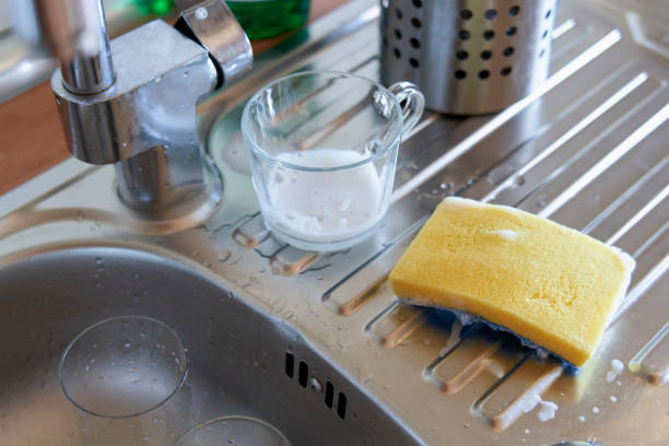 istock Glass cup and sponge with soap and water over the sink 1611587084