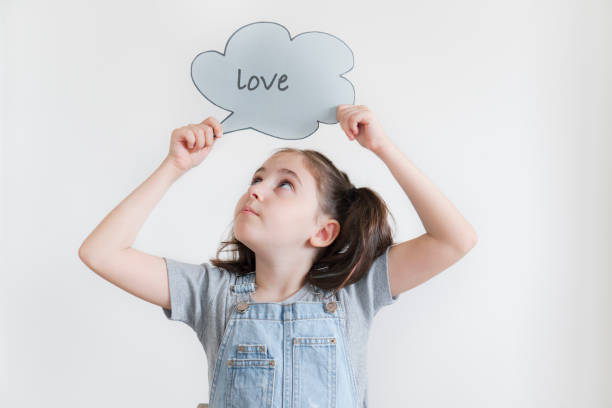 istock Beautiful girl holding speech bubble isolated on white 1611634865
