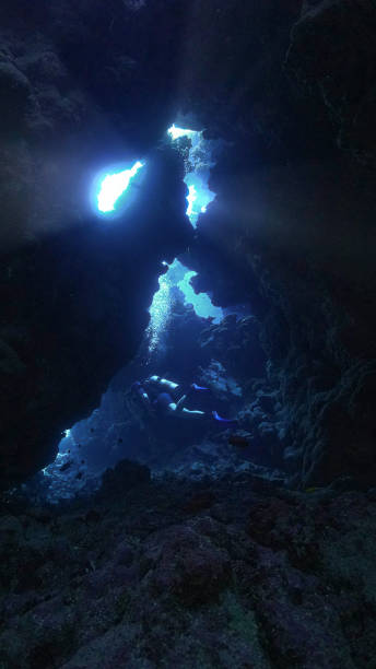 istock Scuba diver inside a cave with rays of sunlight 1611635997