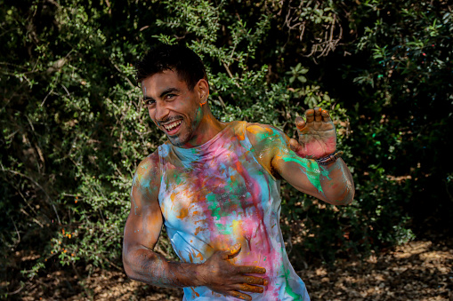 Young man laughling after get soaked with paint by a friend
