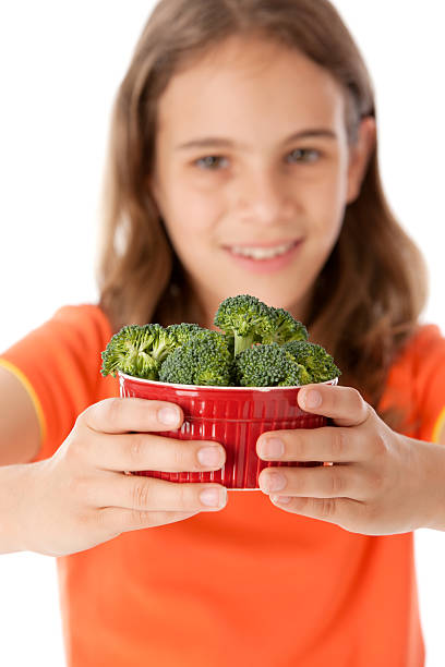 gesunde ernährung: europäischer abstammung kleines mädchen mit brokkoli gemüse kopf und schultern - child portrait fine art portrait multi colored stock-fotos und bilder