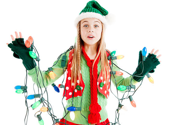 Santas Christmas Elf Tangled in Holiday Lights One of Santa's Christmas Elves is all tangled up in a string of holiday lights. christmas chaos stock pictures, royalty-free photos & images