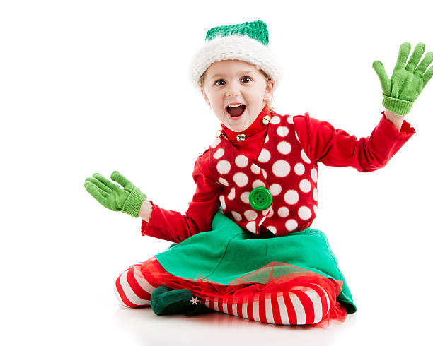 Running. Happy smiling little girl dressed like funny gnome or elf posing isolated over white studio background. Winter, holiday, Merry Christmas and New Year concept. Cute assistant of Santa Claus