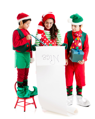 Three hispanic Christmas Elves analyze Santa's list of nice little girls and boys.