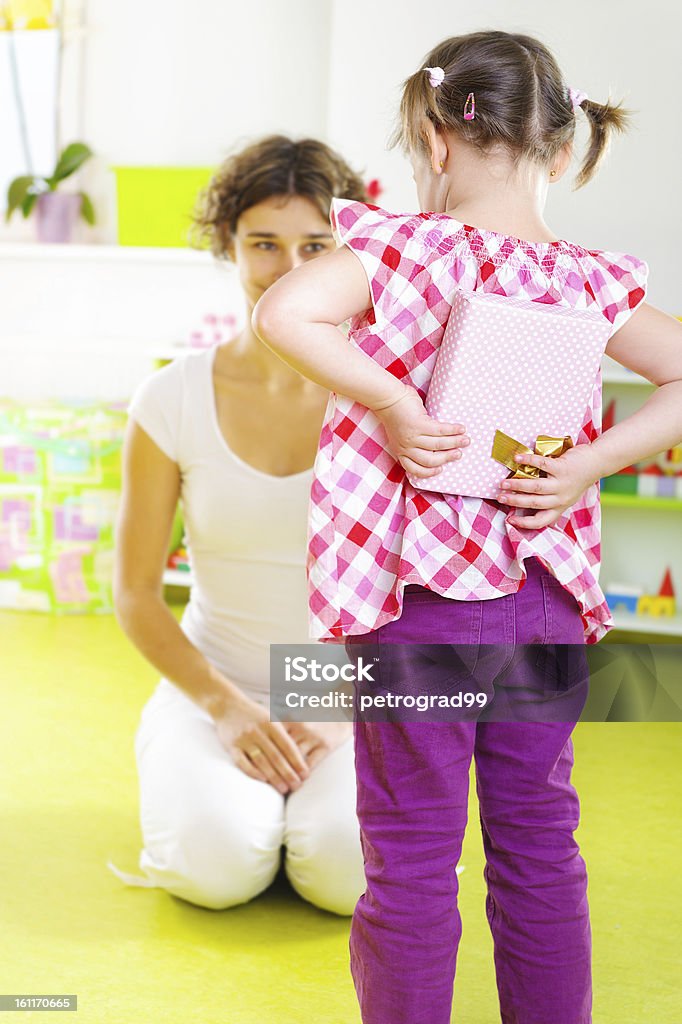 Little girl presenting a gift to her mother Little girl presenting a gift to her mother on Mothers Day Adult Stock Photo