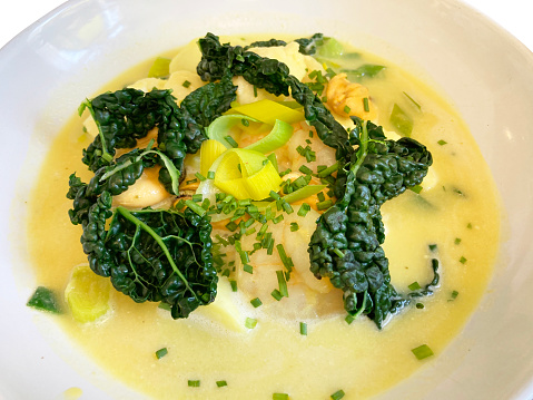 Luxury fish chowder with cavolo nero, leeks and chives.