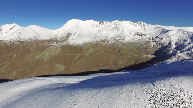 Aerial view of thin fresh snow of the winter season on a treeless high altitude mountain ridge
