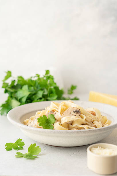 istock Alfredo pasta in bowl on light background close-up view 1611721335