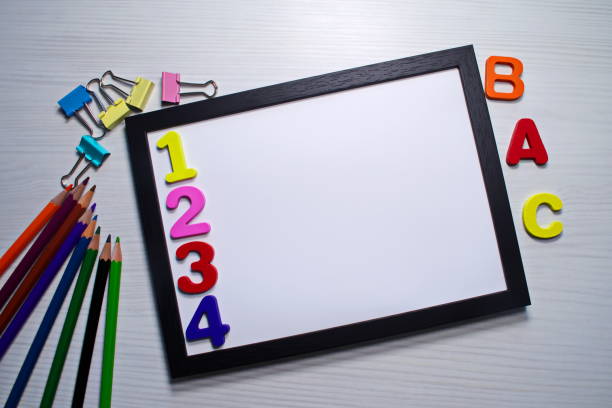 istock Black frame with white blank for text Colored pencils clamps letters around Back to school concept 1611739156