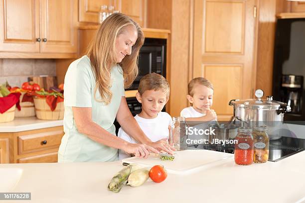 Canning Mother Sons Preserving Homegrown Fruits And Vegetables Stock Photo - Download Image Now