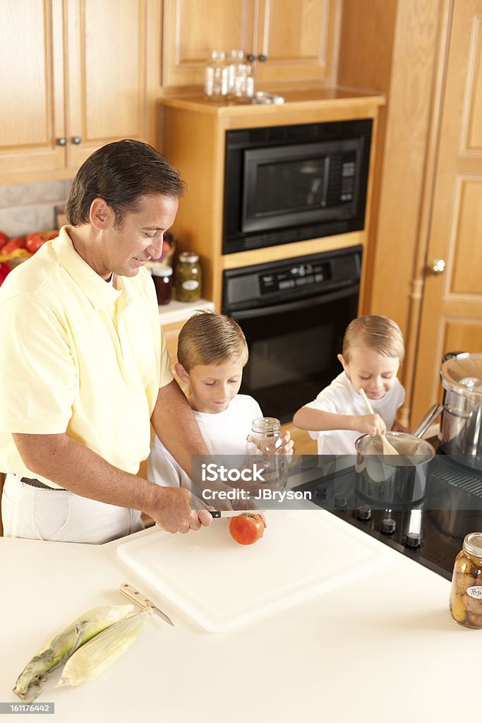 Canning: Father Sons Preserving Homegrown Fruits and Vegetables A high angle view of a caucasian father and his two sons canning homegrown fruits and vegetables. 2-3 Years Stock Photo
