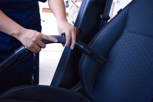 istock Handyman vacuuming car back seat with vacuum cleaner 1611782803