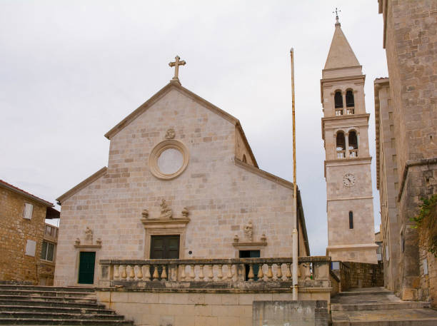 Parish Church and Bell Tower in Supetar, Croatia The 17th century Parish Church of the Annunciation and bell tower in Supetar on Brac Island in Croatia. Known as zupna Crkva Navjestenja Marijina in Croatian old catholic church on island brac croatia stock pictures, royalty-free photos & images