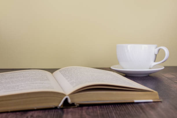 istock An open book and a cup of tea on a wooden table 1611823018