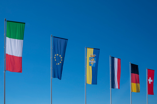 Italian, European and Bardolino flag against a clear blue sky.