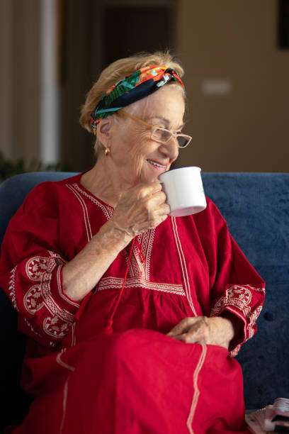 コーヒーを飲む笑顔の幸せな老婆。 - knitting residential structure glasses hot drink ストックフォトと画像