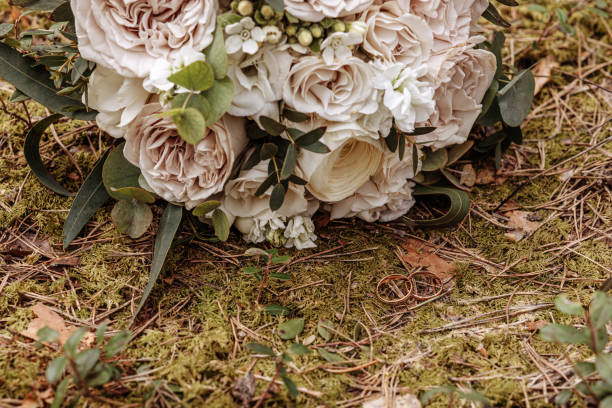 istock Golden wedding rings on forest ground moss background. 1611872715