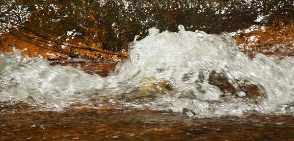 water flowing on the rock and mak wave splashing in river