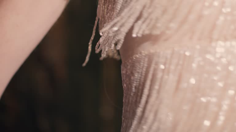 An abstract image of shimmering gold tassels from a dress.