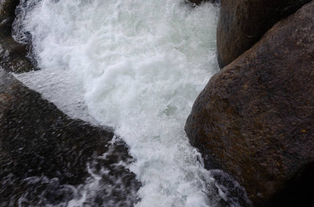 The water from the stream flows peacefully over the rocks.