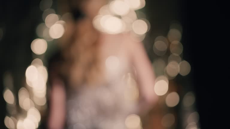 A girl dancing in a dress with passing golden fringes.