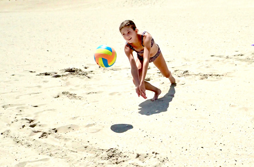 Girl hitting a volleyball on the beach at South Bethany Beach Delaware