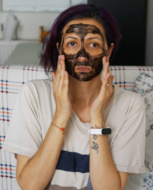 istock woman looking at her face with black mask 1612048688